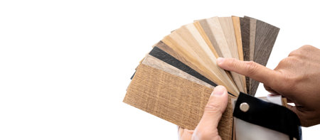 Designer hand pointing at sample of wood laminated material from natural collection. Customer choosing wooden veneer texture or set of MDF board swatch fan for interior finishing or furniture designの写真素材
