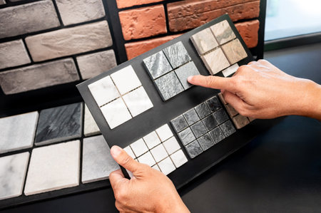 Architect hand pointing at stone tile collection display on sample board. Stone texture and pattern for architectural material ideas. Exterior or interior wall and floor finishing in natural styleの写真素材