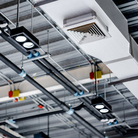 Electrical cable conduits wiring with colorful junction boxes, part of plumbing pipeline and ceiling air vent duct in modern building. Pipe and fitting for power, plumbing and air conditioning systemsの写真素材