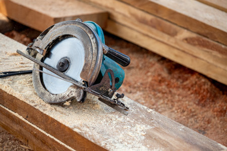 Electric circular saw on timber stack. Work tool for carpentry in a wood workshop used for cutting wooden plank. Lumber industry conceptの写真素材