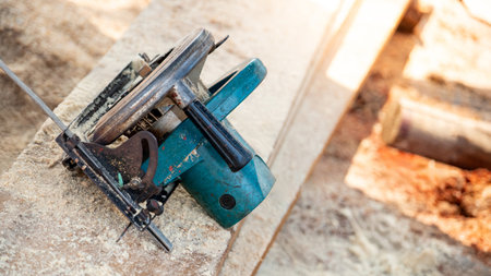 Electric circular saw on timber stack in a wood workshop. Work tool for carpentry used for cutting wooden plank or board. Lumber industry conceptの写真素材