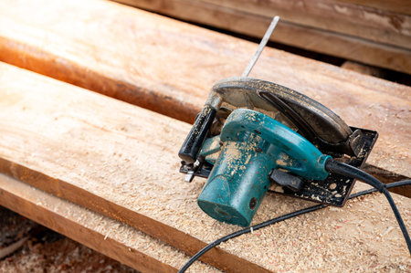 Electric circular saw on timber stack. Work tool for carpentry in a wood workshop used for cutting wooden plank. Lumber industry conceptの写真素材