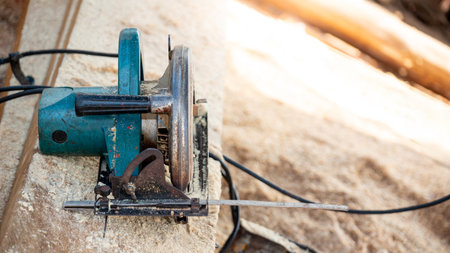 Electric circular saw on timber stack in a wood workshop. Work tool for carpentry used for cutting wooden plank or board. Lumber industry conceptの写真素材