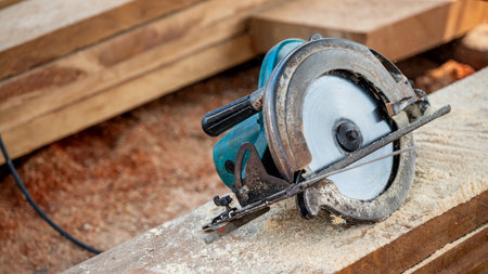 Electric circular saw on timber stack in a wood workshop. Work tool for carpentry used for cutting wooden plank or board. Lumber industry conceptの写真素材