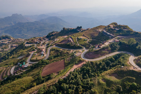 Aerial view of curvy road and winding path on the mountain with lots of hillside tourist resorts up...