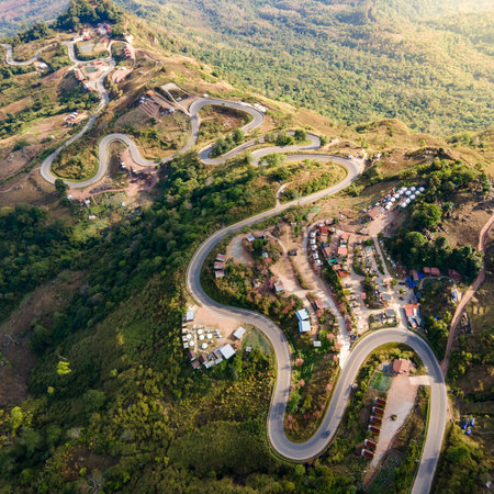 Aerial view of curvy road and winding path on the mountain with lots of hillside tourist resorts up...
