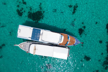 Aerial view of two recreational vessels or scuba diving boat anchoring together over turquoise clear water at Racha Island or Koh Racha, A popular destination for summer vacation in Phuket, Thailand.の写真素材
