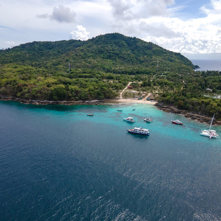 Aerial view of Koh Racha Yai Island with many tour boats, yacht, catamaran and longtail boat anchoring around the bay. A popular destination for summer vacationの写真素材