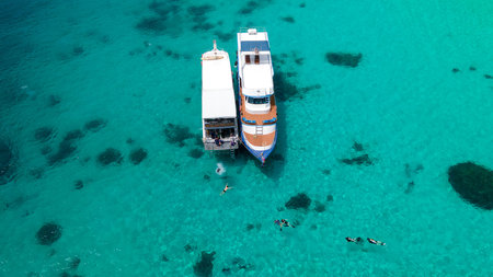 Aerial view of two recreational vessels or scuba diving boat anchoring together over turquoise clear water at Racha Island or Koh Racha, A popular destination for summer vacation in Phuket, Thailand.の写真素材