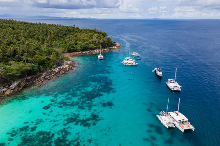 Aerial view of Koh Racha Yai Island with many tour boats, yacht, catamaran and longtail boat anchoring around the bay. A popular destination for summer vacationの写真素材