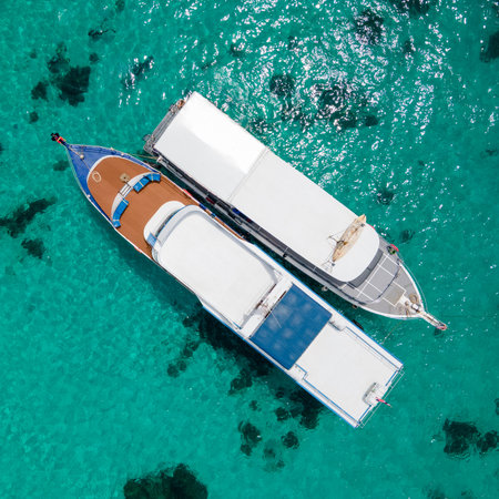 Aerial view of two recreational vessels or scuba diving boat anchoring together over turquoise clear water at Racha Island or Koh Racha, A popular destination for summer vacation in Phuket, Thailand.の写真素材