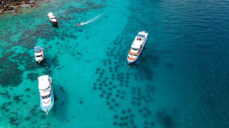 Aerial view of Racha Yai Island or Koh Raya with tourboat, yacht and diving boat anchoring over the artificial reef. A popular destination for summer vacationの写真素材