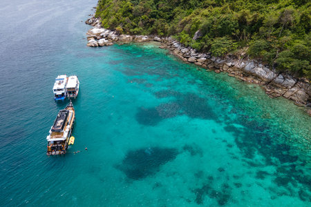 Group of recreational vessels or scuba diving boats anchoring over turquoise clear water at Racha Noi Island or Koh Racha Noi in Phuket, Thailand. Aerial view of a popular destination in Andaman seaの写真素材