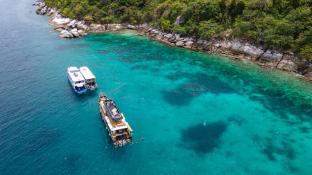 Group of recreational vessels or scuba diving boats anchoring over turquoise clear water at Racha Noi Island or Koh Racha Noi in Phuket, Thailand. Aerial view of a popular destination in Andaman seaの写真素材