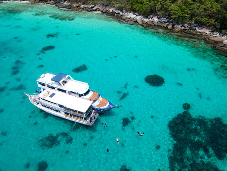 Aerial view of two recreational vessels or scuba diving boat anchoring together over turquoise clear water at Racha Island or Koh Racha, A popular destination for summer vacation in Phuket, Thailand.の写真素材