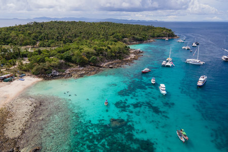 Aerial view of Koh Racha Yai Island with many tour boats, yacht, catamaran and longtail boat anchoring around the bay. A popular destination for summer vacationの写真素材