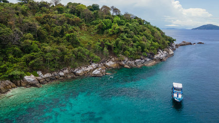 PHUKET, THAILAND - APRIL 24, 2025 : Aerial view of recreational vessel or scuba diving boat anchoring over turquoise clear water at Racha Island or Koh Racha, A popular destination for summer vacationの写真素材