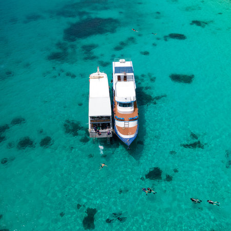 Aerial view of two recreational vessels or scuba diving boat anchoring together over turquoise clear water at Racha Island or Koh Racha, A popular destination for summer vacation in Phuket, Thailand.の写真素材
