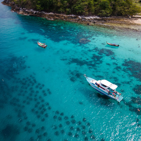 Aerial view of Koh Racha Yai Island with tourboat and longtail boat anchoring in front of the bay. A popular destination for summer vacation activityの写真素材