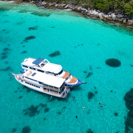 Aerial view of two recreational vessels or scuba diving boat anchoring together over turquoise clear water at Racha Island or Koh Racha, A popular destination for summer vacation in Phuket, Thailand.の写真素材