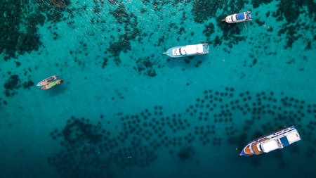 Aerial view of Koh Racha Yai Island with tour boat, yacht longtail boats anchoring over the artificial reef. A popular destination for summer vacationの写真素材