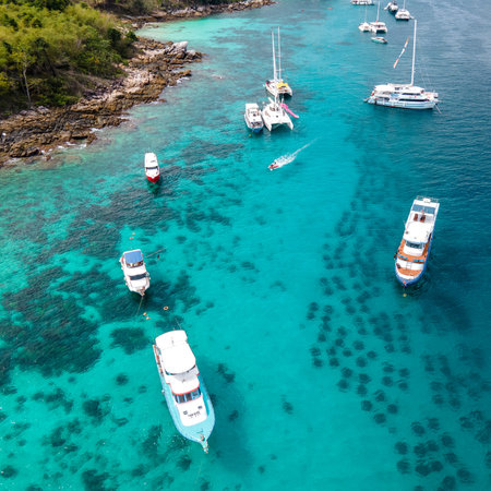 Aerial view of Racha Yai Island or Koh Raya with tour boats, yacht, catamaran and longtail boat anchoring around the bay. A popular destination for summer vacationの写真素材