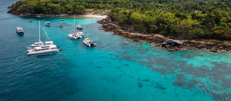 Aerial view of Racha Yai Island or Koh Raya with tour boats, yacht, catamaran and longtail boat anchoring around the bay. A popular destination for summer vacationの写真素材