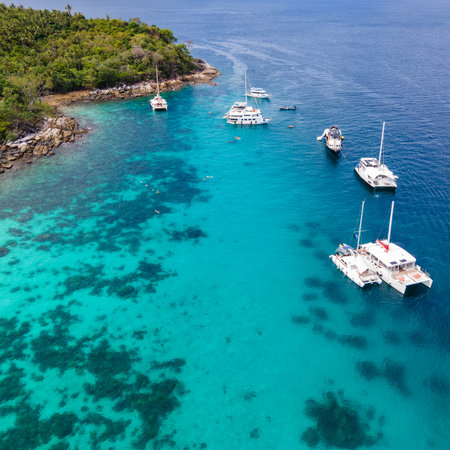 Aerial view of Koh Racha Yai Island with many tour boats, yacht, catamaran and longtail boat anchoring around the bay. A popular destination for summer vacationの写真素材