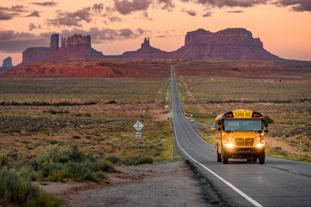 Yellow school bus on US highway route 163 during sunrise at Forrest Gump Point, a scenic road in...