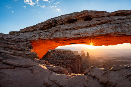 Mesa Arch at sunrise, a spectacular natural stone arch perched at the edge of a cliff in Canyonlands National Park in northern San Juan County, Utah, United States.の写真素材