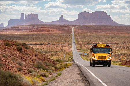 Yellow school bus on US highway route 163 at Forrest Gump Point, a scenic road in Monument Valley...