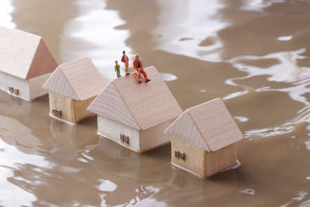 Homes submerged by river flooding and isolated peopleの写真素材