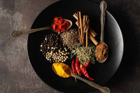 Spices and spices on a spoon on black background