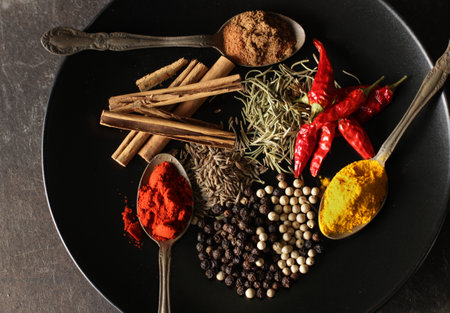 Spices and spices on a spoon on black backgroundの写真素材