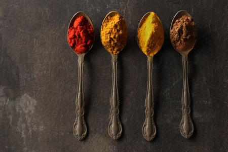 Spices and spices on a spoon on black backgroundの写真素材