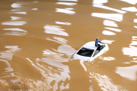 Diorama of a car stuck in flood and people waiting for rescueの写真素材