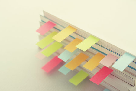 Colorful sticky notes sandwiched between books and materials