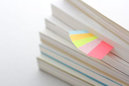 Colorful sticky notes sandwiched between books and materials