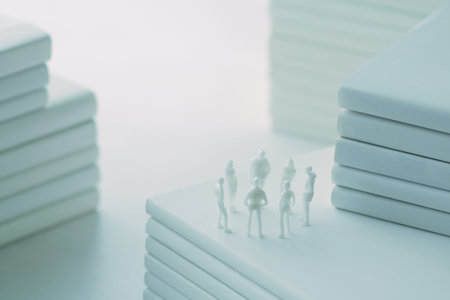Stacked white books and miniature human dolls