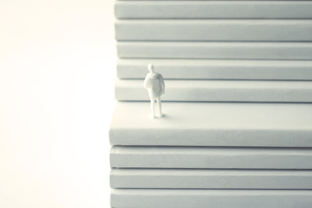 Stacked white books and miniature human dollsの写真素材