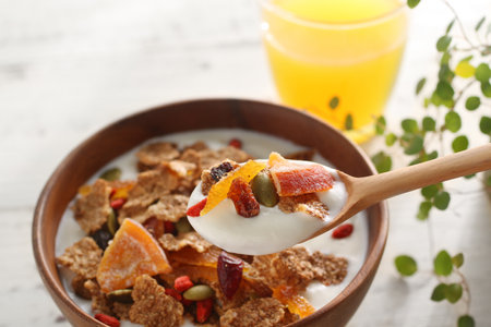 Breakfast of cereals and fruits and nuts poured with yogurtの写真素材