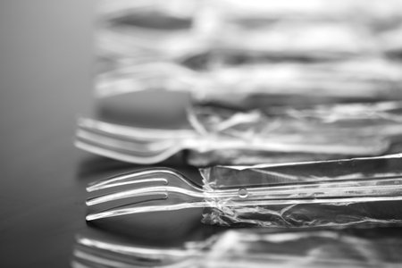 Plastic spoons and forks on a black backgroundの写真素材