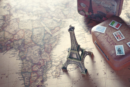 Image of overseas travel using a world map, an airplane and a model of the Eiffel Tower