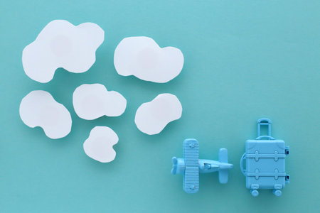 Image of an international trip on a blue background with model of an airplane and cloudsの写真素材