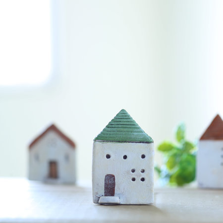 An image of a soft home full of light with a model of a small house placed by the windowの写真素材
