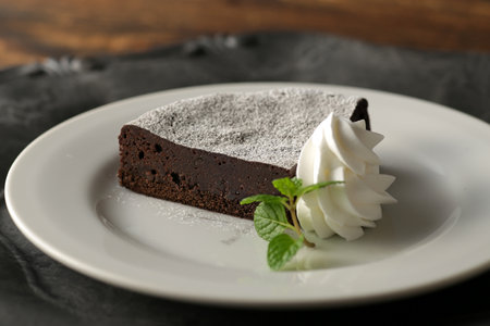 Cheesecake and chocolate cake served on a plate with strawberry sauceの写真素材