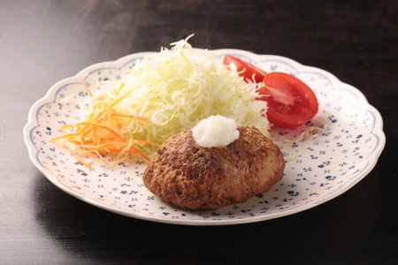 Juicy and delicious looking hamburger steak served on a plate or grilled on a hot plateの写真素材