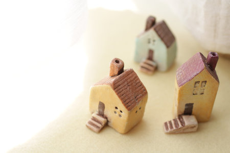 A cute little miniature house placed by a window where light shines inの写真素材
