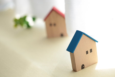 A cute little miniature house placed by a window where light shines inの写真素材