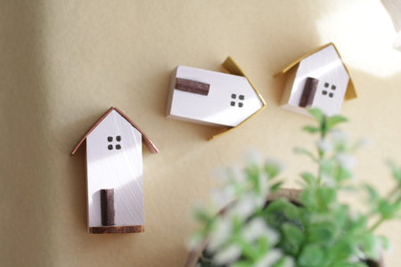 A cute little miniature house placed by a window where light shines inの写真素材